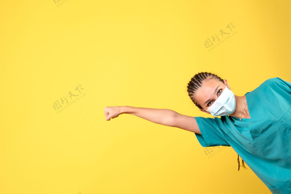 黄色正面图：穿着医用衬衫和面罩的女医生 大流行卫生医院的彩色护士颜色复制空间面具