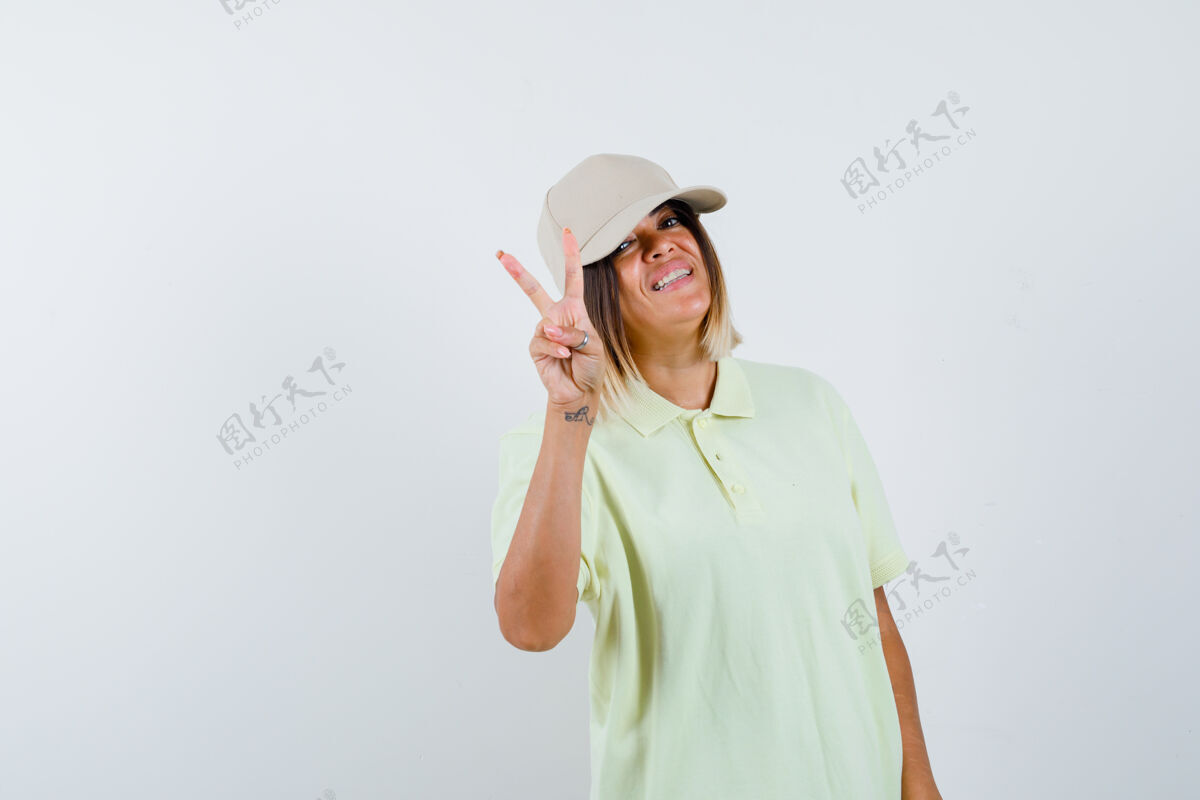 女孩穿着t恤和帽子的年轻女孩展现出平和的姿态 看起来很开心 正面视图护理乐趣情感