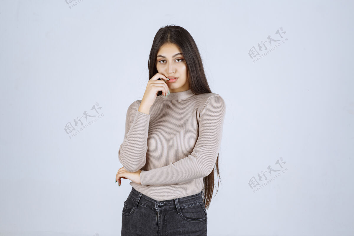女人穿灰色衬衫的女孩摆出积极而吸引人的姿势雇员诱惑休闲