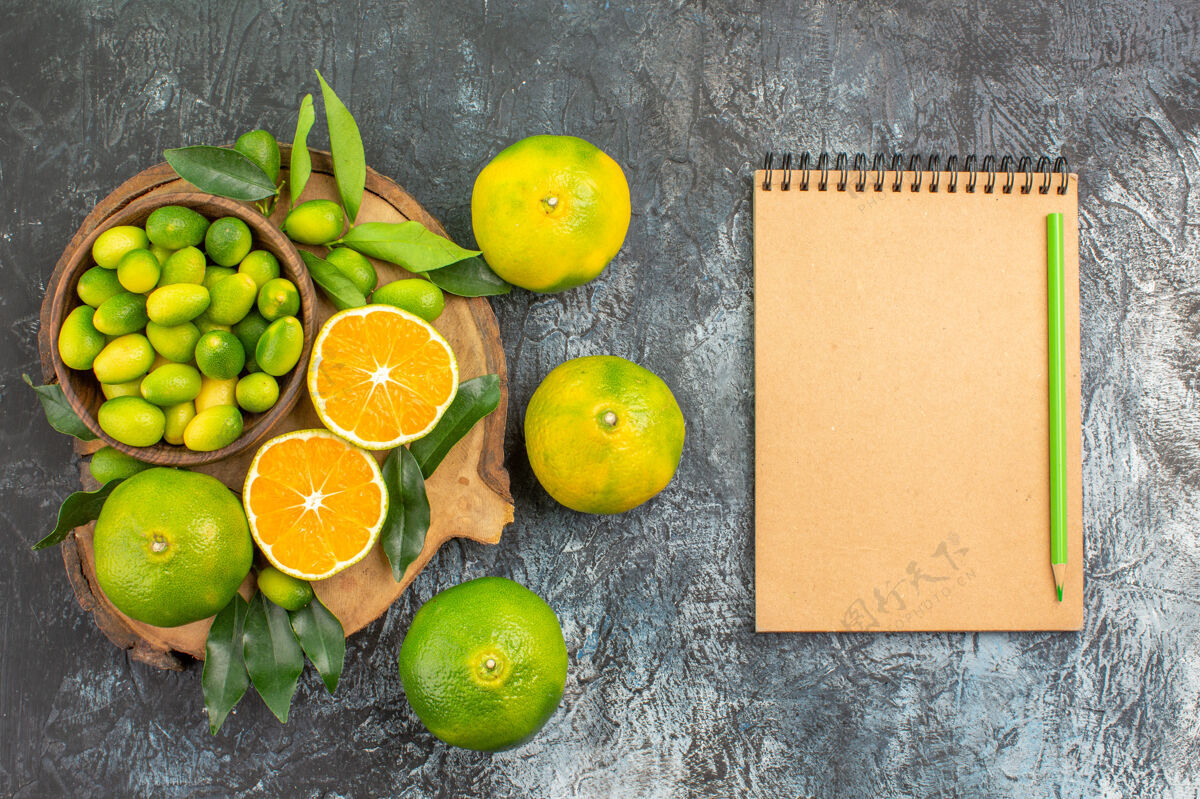 柑橘顶视柑橘水果板上有不同种类的柑橘水果笔记本铅笔善良柠檬酸橙