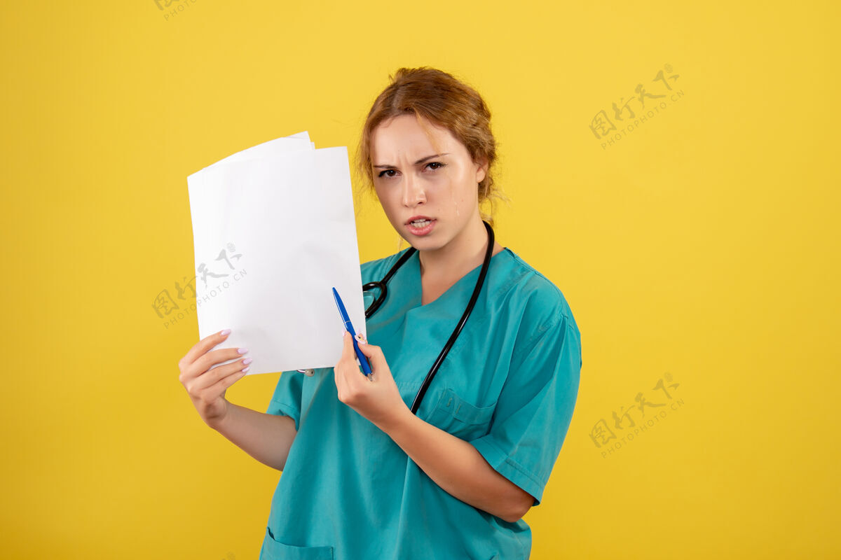 医学黄墙上穿着医疗服的女医生手持分析图女医生医学分析