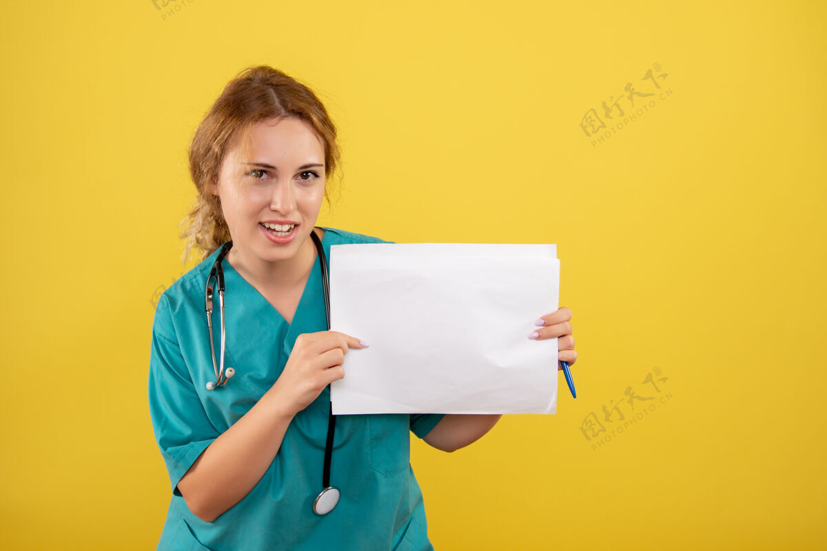 持有黄墙上穿着医疗服的女医生手持分析图西装医疗病毒