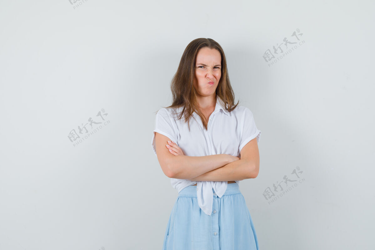 女人一位身穿衬衫 裙子的年轻女士交叉着双臂站着 撅着嘴 看上去很生气冒犯时尚性感