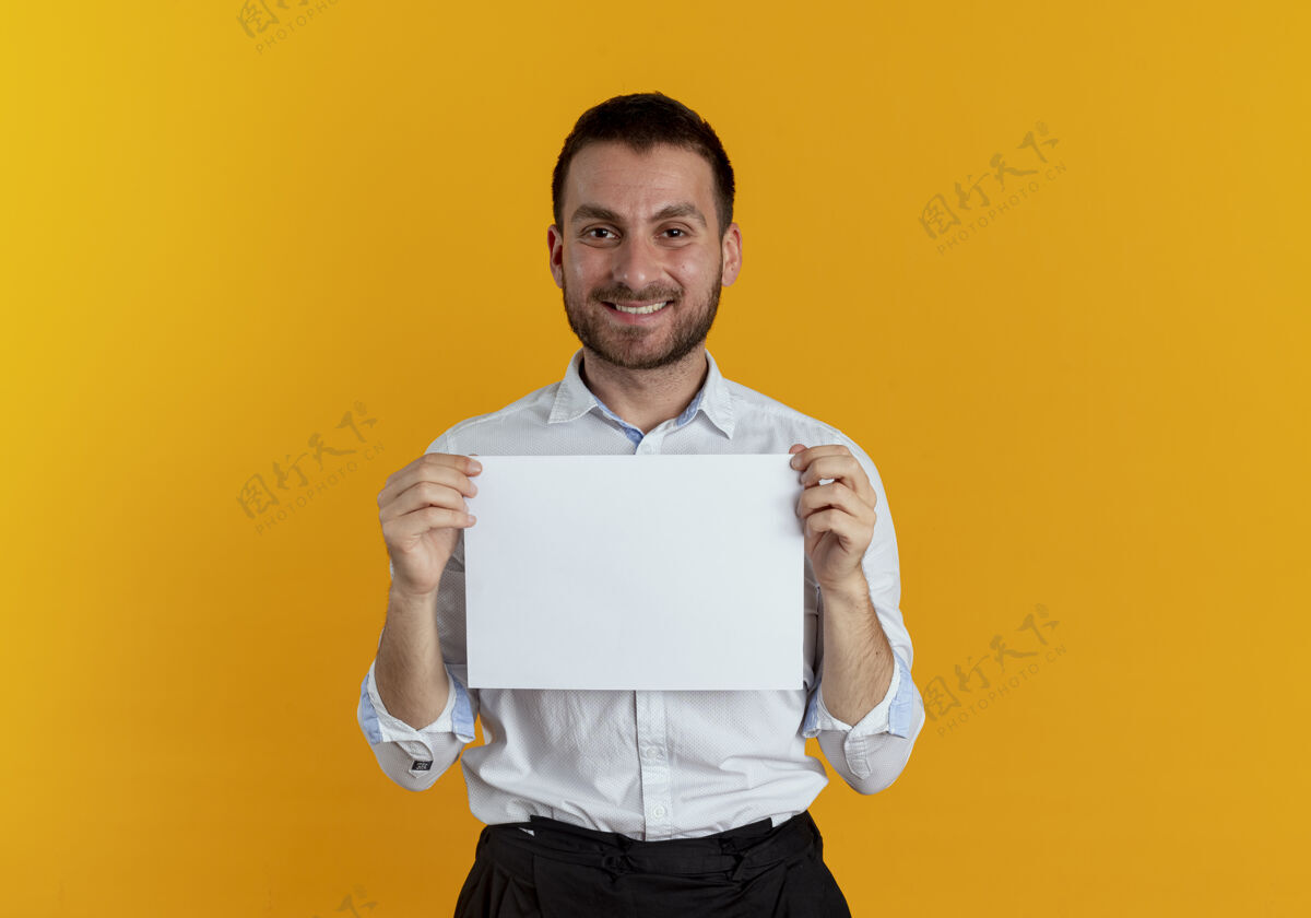 男人笑容可掬的帅哥拿着纸纸孤零零地贴在橘色的墙上商人年轻海报