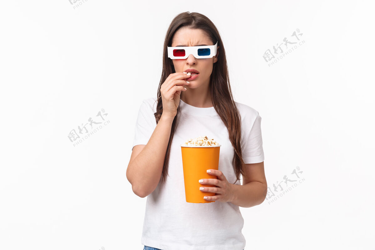 欢乐一个吃着爆米花 戴着3d眼镜的年轻女人人物年轻肖像
