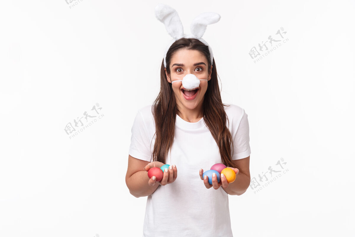 商业肖像富有表现力的年轻女子戴着兔子的耳朵和鼻子 手里拿着彩蛋时尚折扣快乐