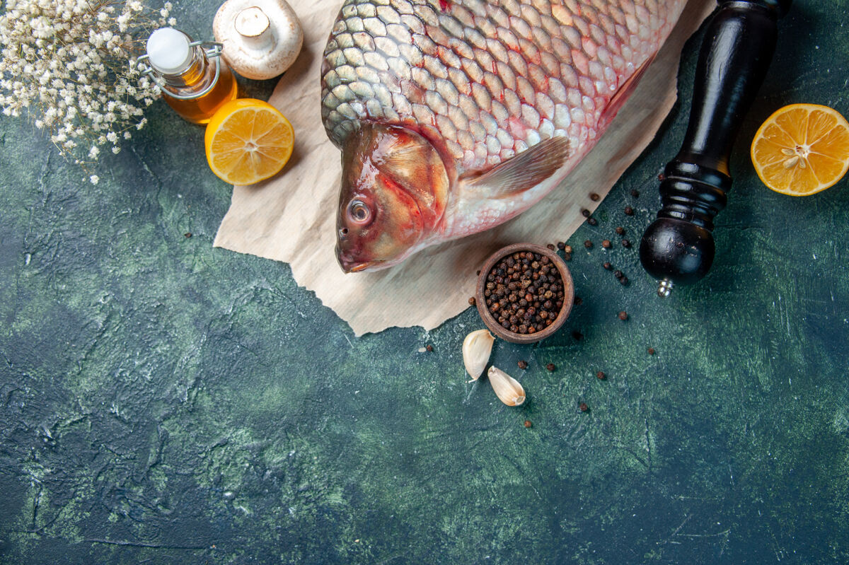 食物在深蓝色的背景上俯瞰新鲜的生鱼肉和蘑菇餐顶部肉