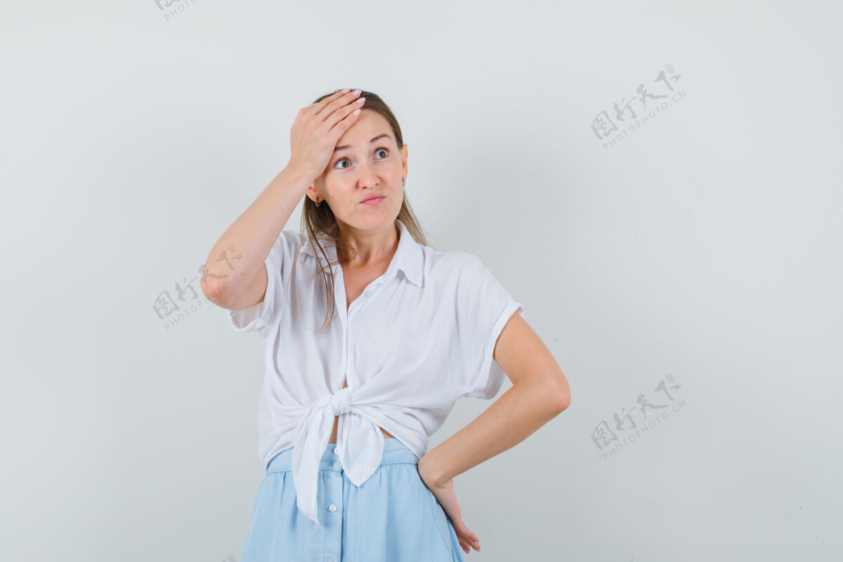 年轻一位穿着衬衫和裙子的年轻女士手挽着头 看上去很抱歉健康护理干净