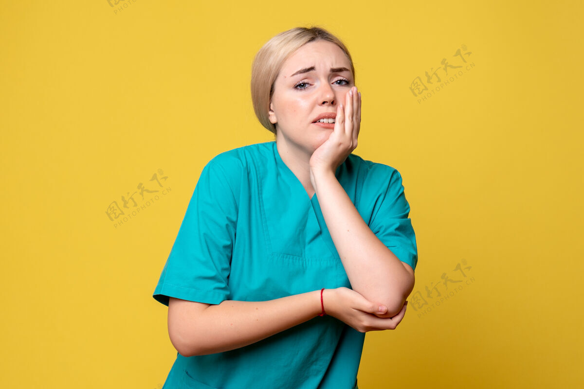 微笑黄墙上年轻女医生穿着医用衬衫手臂受伤的正面图成人情绪年轻女医生