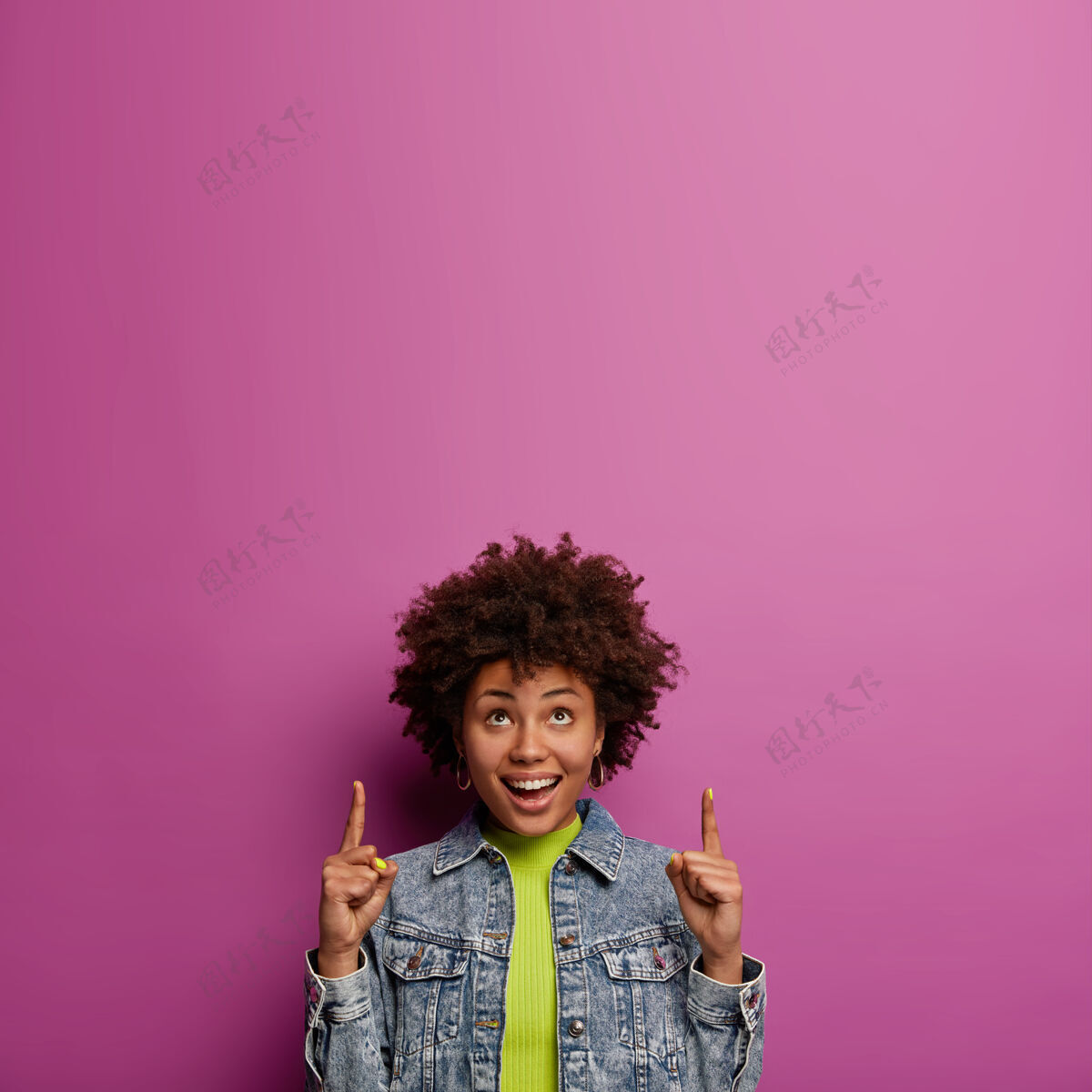 发型漂亮的美国黑人女人用食指指着上面微笑向上好奇