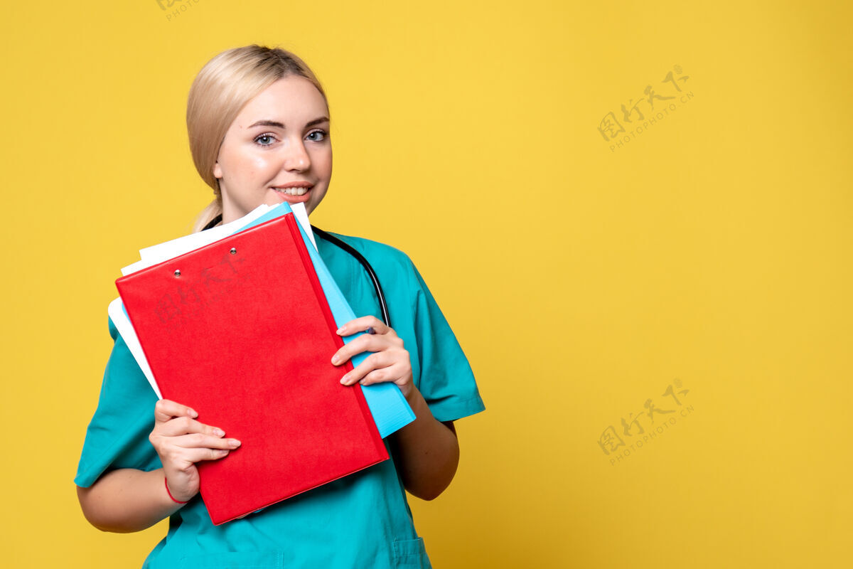 黄色前视图女医生拿着笔记和文件 病毒科-19护士健康医疗医院女人肖像微笑