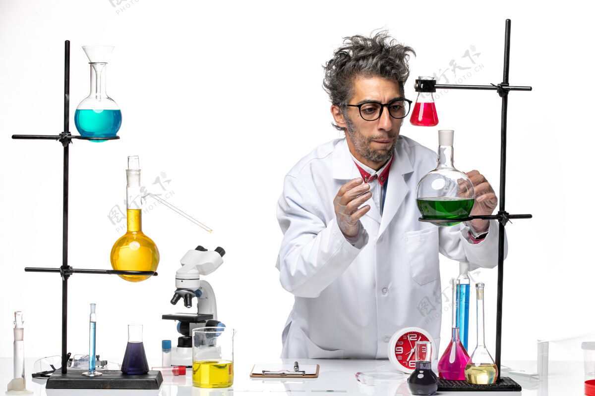 实验室前视图身着医疗服的男科学家正在用不同的溶液研究白色背景化学冠状病毒-实验室病毒医学医生观点