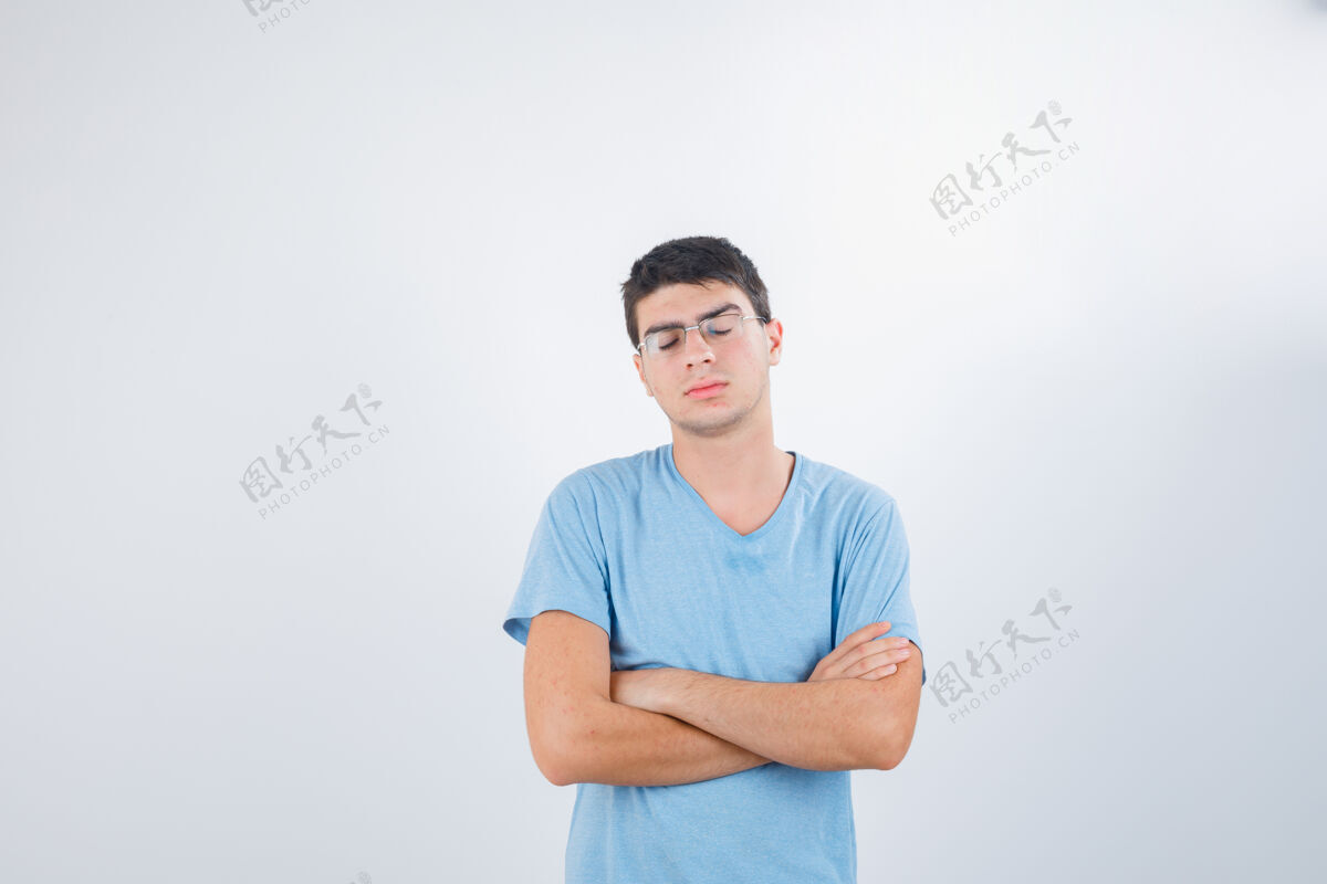 脱衣服年轻男子交叉双臂站在t恤衫上 看上去很失望 正面视图站立黑发严肃