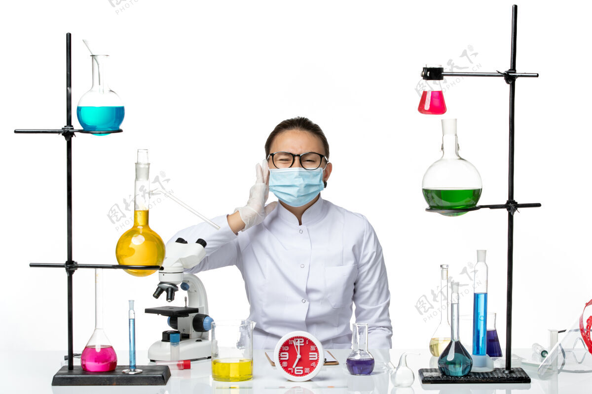 医生前视图穿着医疗服的女化学家戴着口罩在白色背景上忍受疼痛化学病毒实验室病毒-飞溅西装前面痛苦