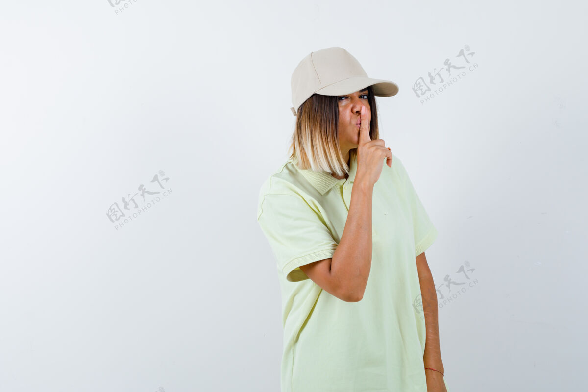 手势年轻女性穿着t恤 戴着帽子 摆出沉默的姿态 严肃地看着前方帽子时尚水疗