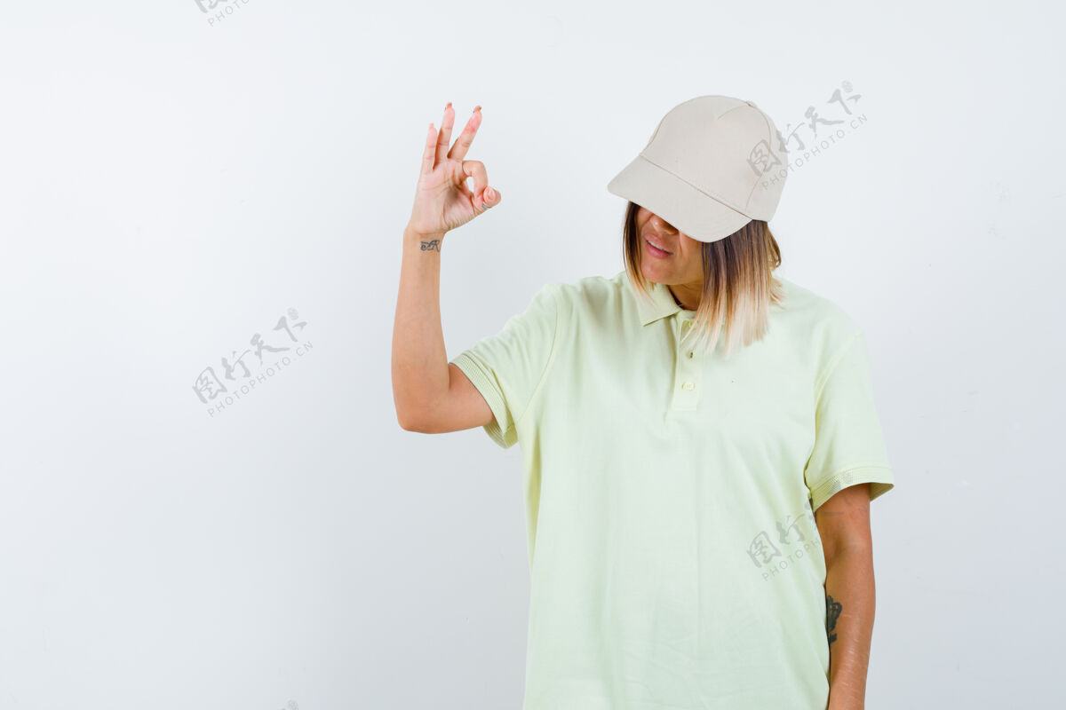 眼睛年轻女性穿着t恤 戴着帽子 看起来很自信正面图时尚女孩清洁