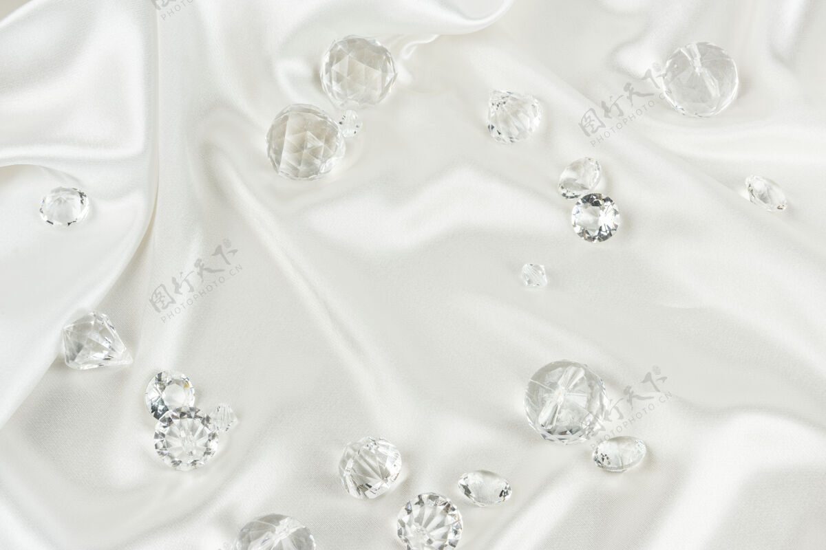 宝石白色织物纹理背景上的装饰性透明钻石珠宝优雅豪华
