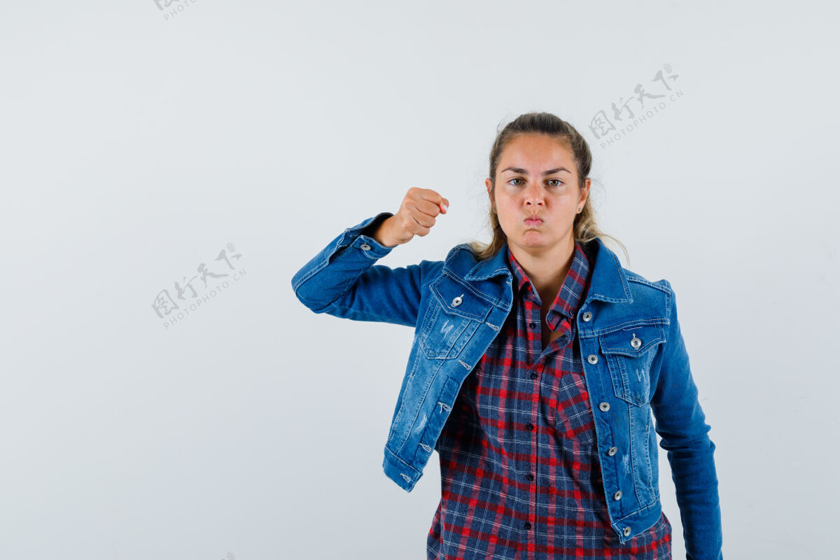 黑发年轻的女士威胁与拳头在衬衫 夹克衫和看起来恶意 前视图女人衬衫视图