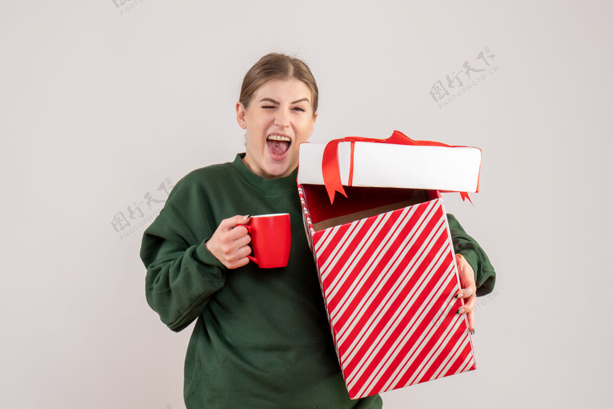 美丽前视图年轻女性 圣诞礼物和一杯茶茶杯子年轻女性