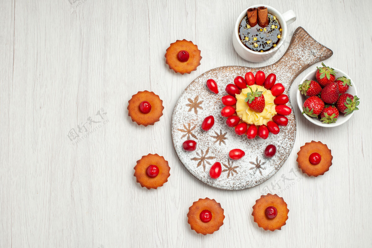 花顶视图：白色桌子上有水果 茶和蛋糕的小蛋糕花帽子食物