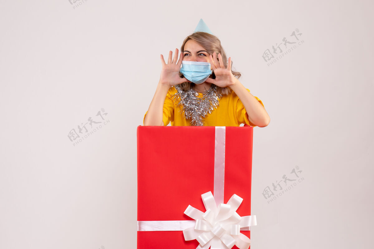 礼品正面图：戴着面具的红色礼品盒里的年轻女性盒子圣诞节快乐