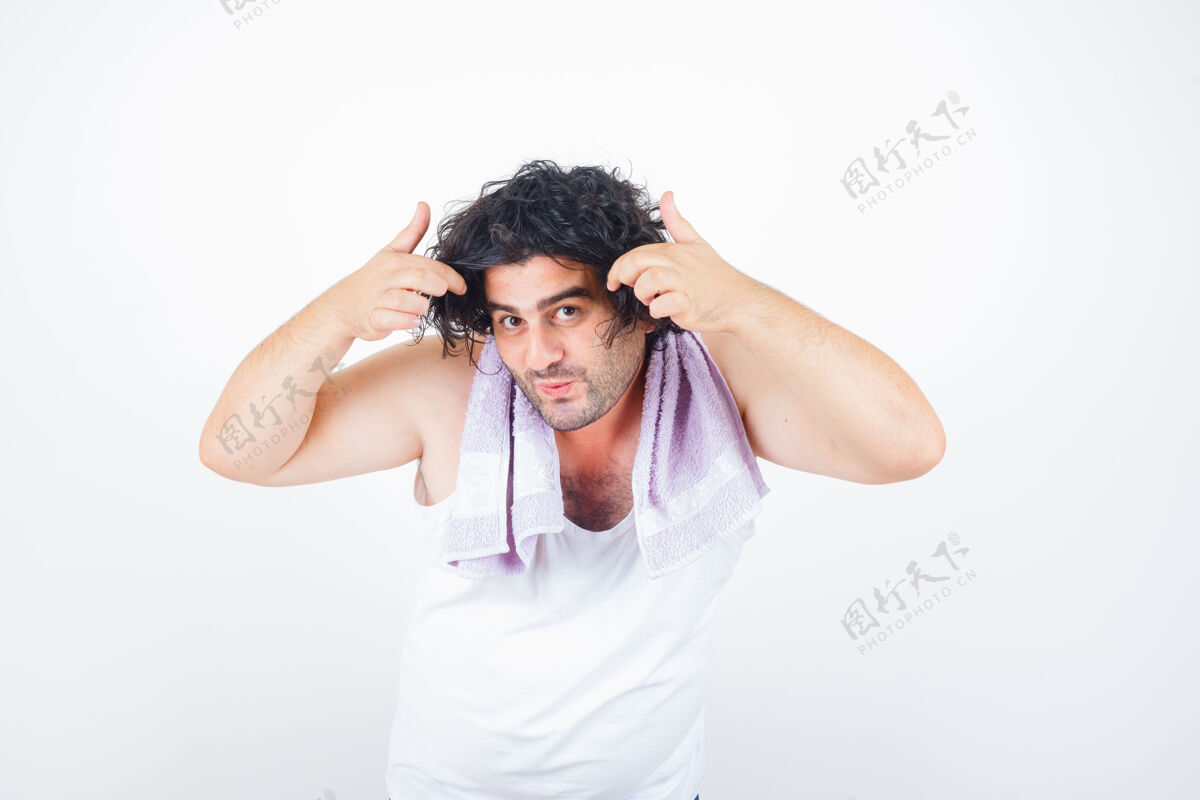 活跃中年男子穿着背心 手巾托着一缕头发 一边看着镜头 看上去很可爱 前视图前面丈夫成熟