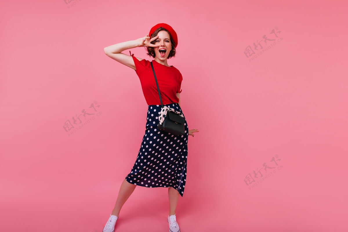 可爱兴奋的法国女人玩得很开心的全长肖像穿着红色贝雷帽跳舞的快乐的高加索女士放松贝雷帽搞笑