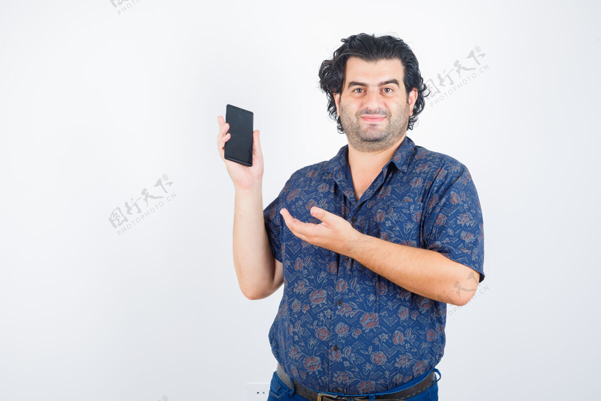 休闲成熟的男人穿着衬衫展示手机 看起来很自信正面视图微笑室内衬衫