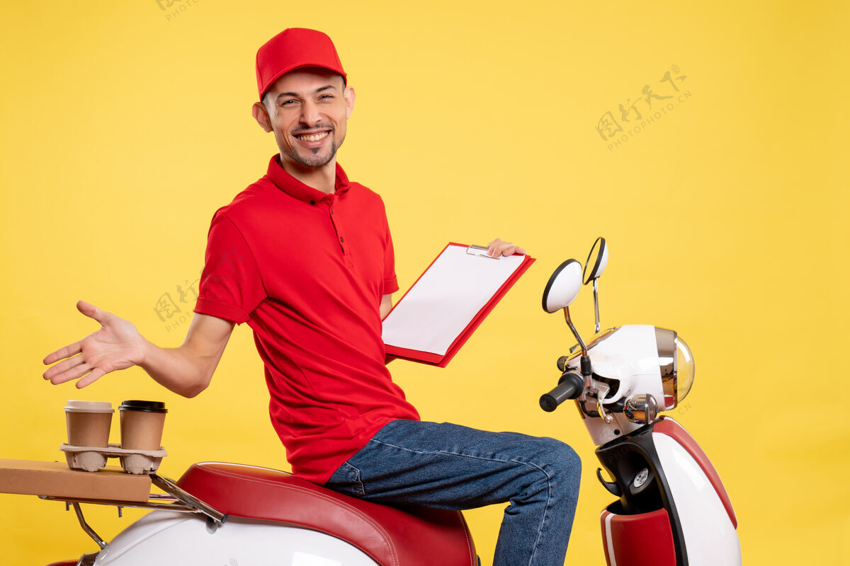 男正面图身着红色制服的男快递员在黄色送货自行车上贴着文件说明工作制服工人服务工作红色男视图