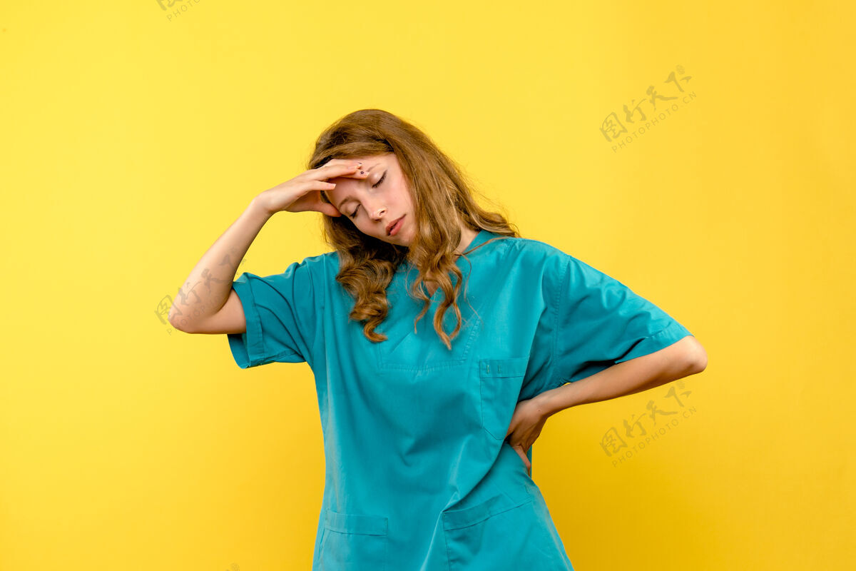 快乐黄墙上女医生的正面图制服女人模特
