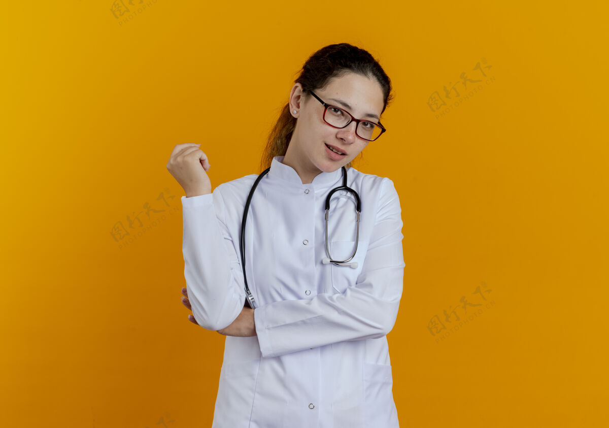 长袍高兴的年轻女医生穿着医疗袍和听诊器与眼镜隔离年轻人人女士