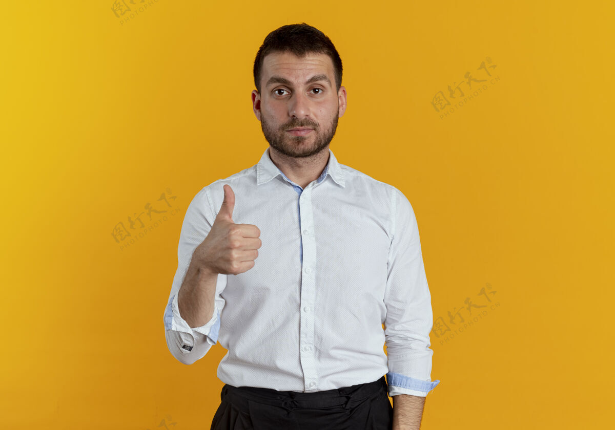 自信自信帅哥竖起大拇指孤零零地站在橙色的墙上优雅商务男士竖起大拇指