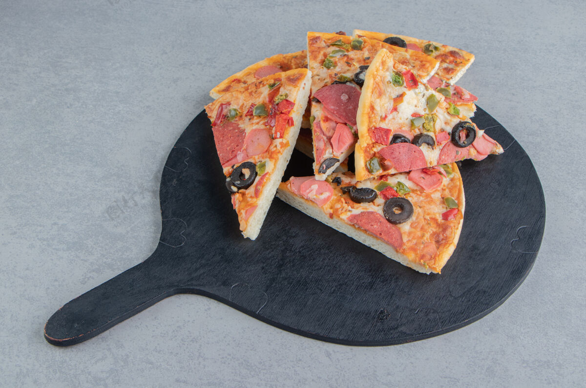 晚餐一小堆披萨片放在一块黑色的大理石板上午餐皮比萨饼