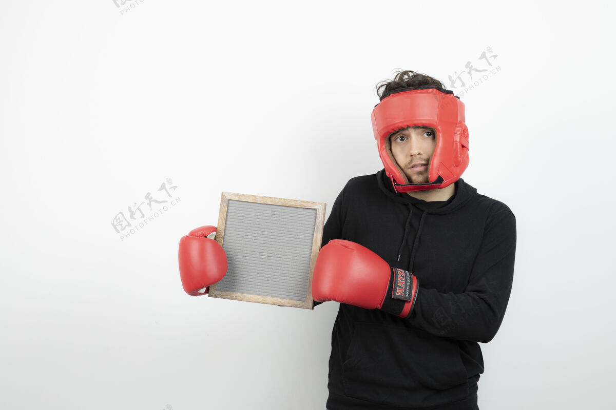 人一个戴着红色拳击帽的年轻运动员举着空镜框的画像运动年轻拳击手