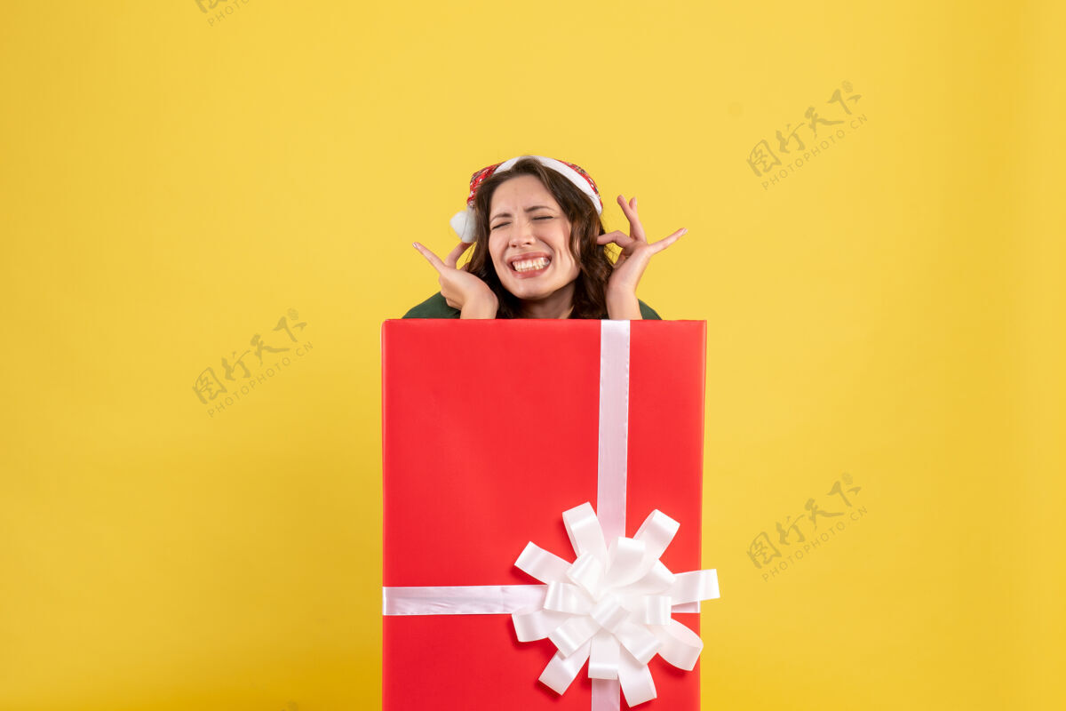 视图正面图年轻女性藏在黄色的礼物盒里购物黄色盒子