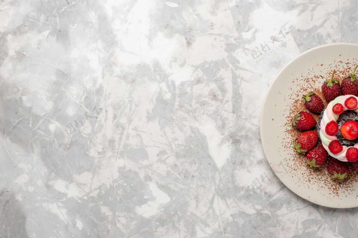 浆果顶视图新鲜的红色草莓和蛋糕在浅白色的空间图案蛋糕饼干