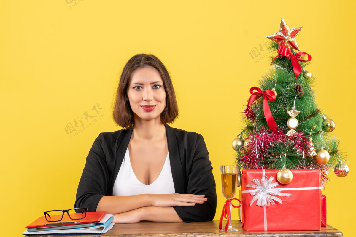 微笑新年心情带着年轻快乐感性的商务小姐坐在黄色办公桌旁漂亮年轻情绪