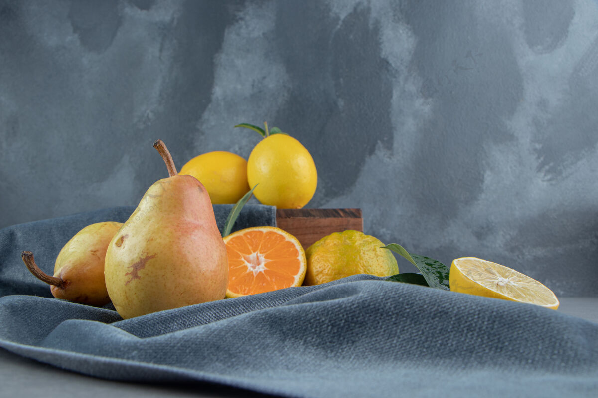 柑橘柠檬 橘子和梨放在一块布上 放在木板上 放在大理石上营养柠檬柑橘