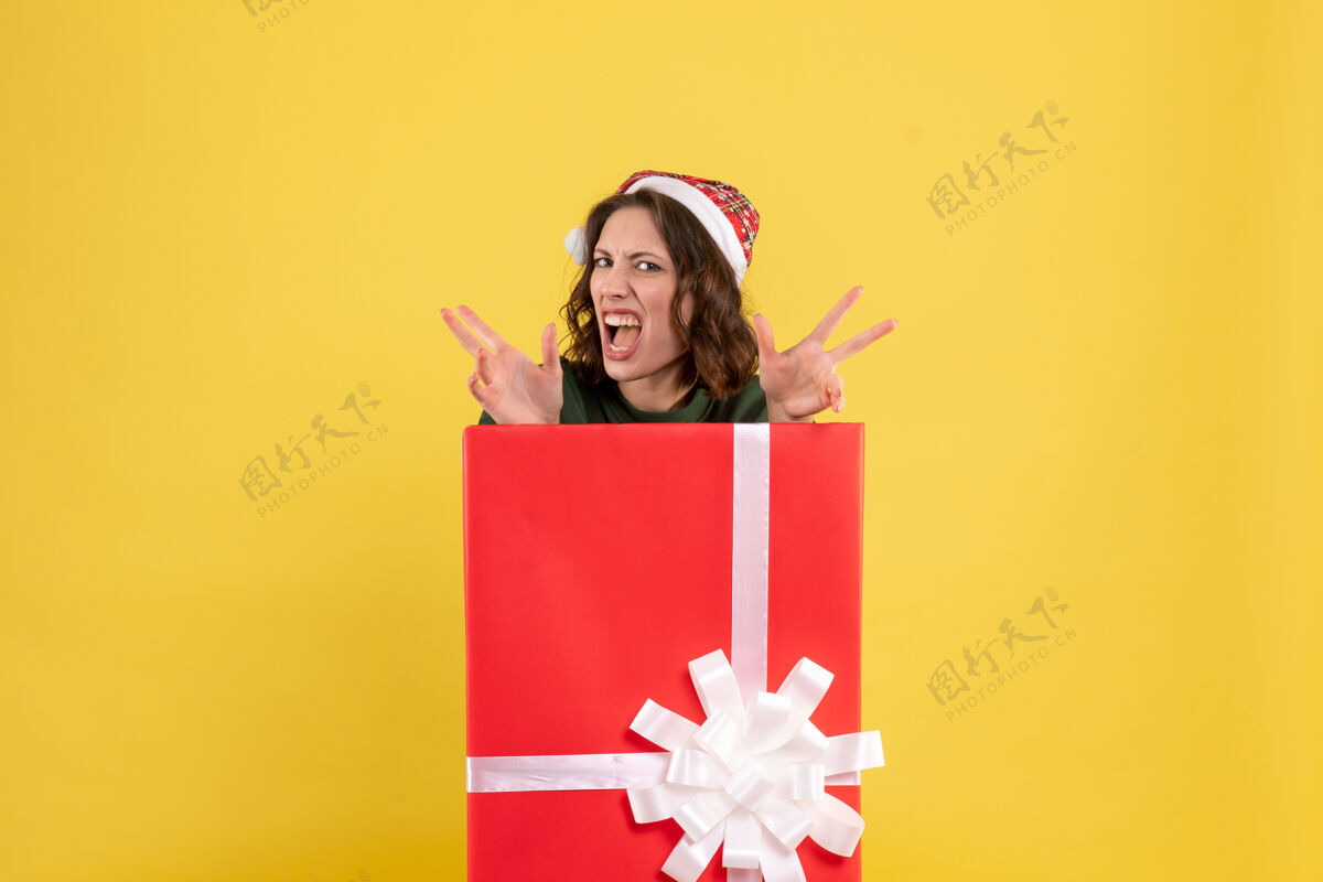 礼物正面图年轻女性藏在黄色的礼物盒里礼物前面年