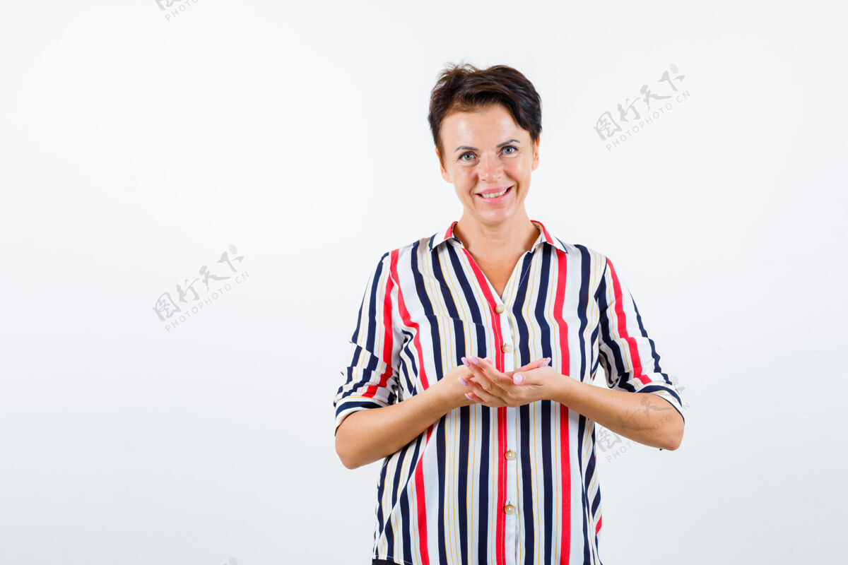 女性成熟的女人 穿着条纹衬衫 假装手里拿着什么东西 看起来很快乐 正面照中间快乐手