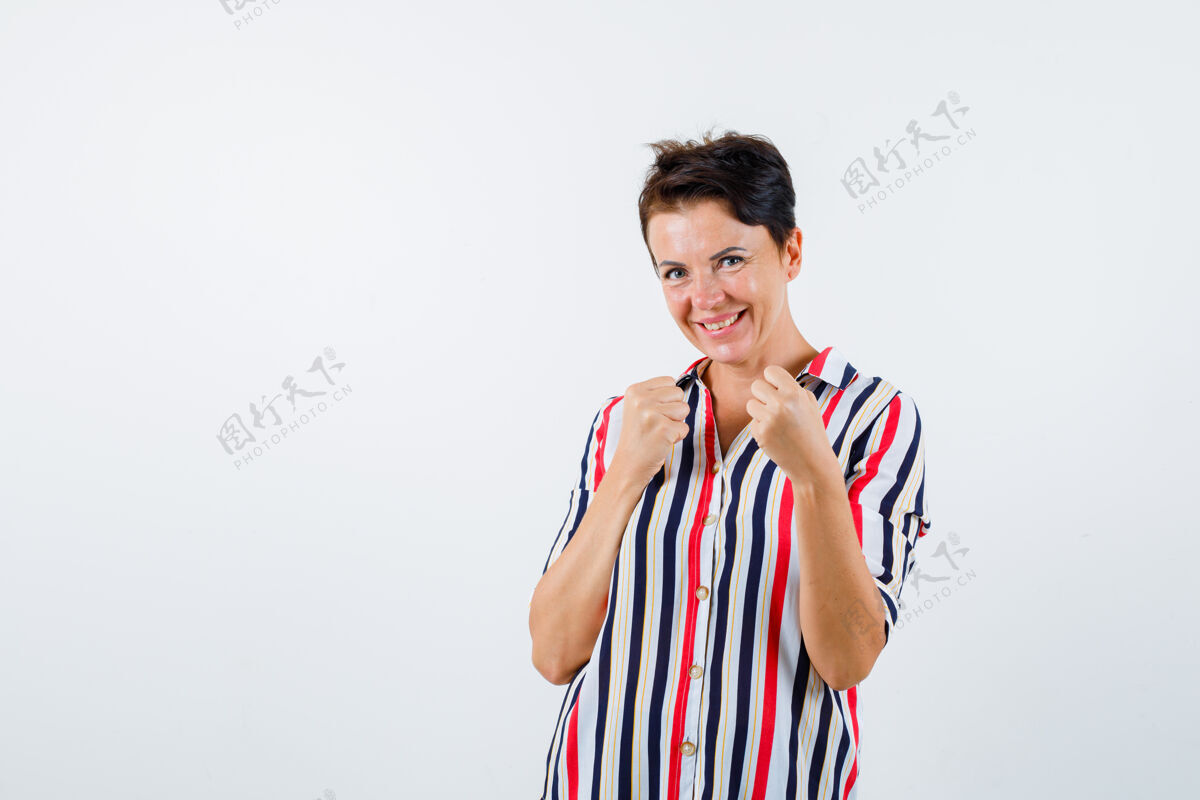 商务穿着条纹衬衫的成熟女人站成拳击姿势 看起来很活泼 正面视图优雅女士年龄