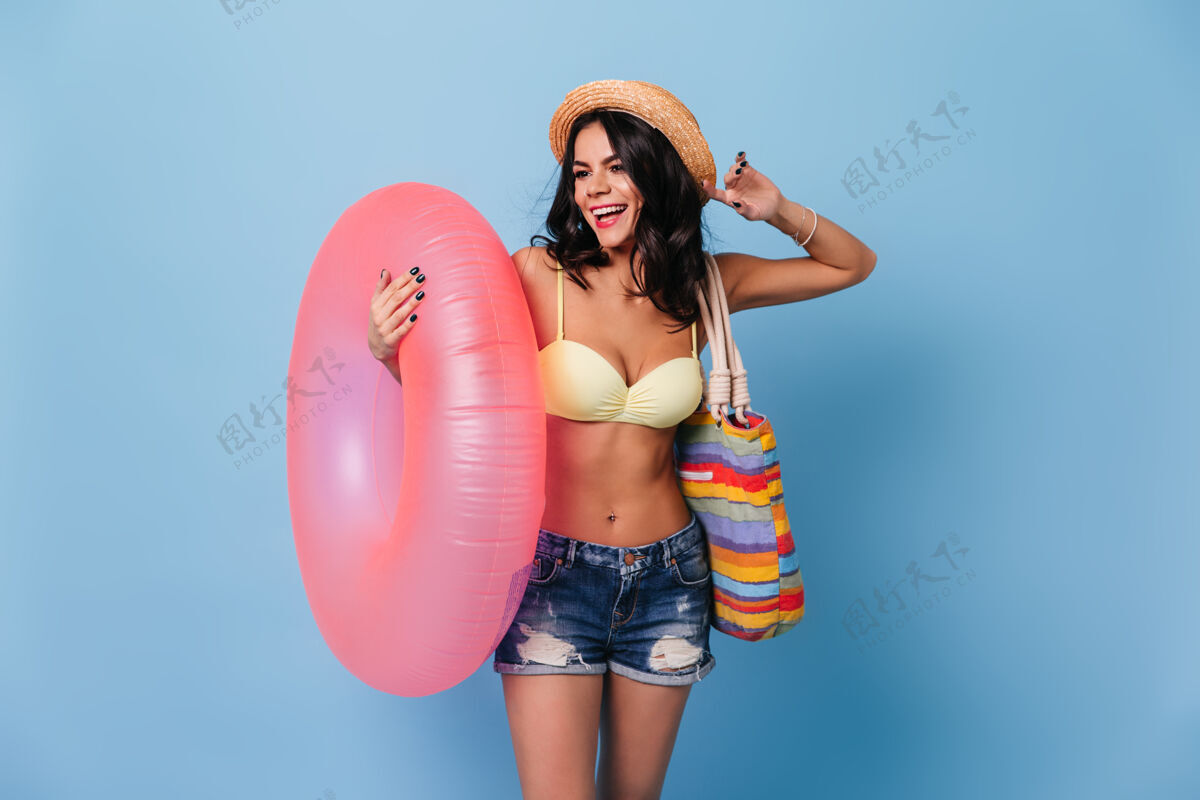 草帽手持粉色游泳圈的漂亮女人情感配饰微笑
