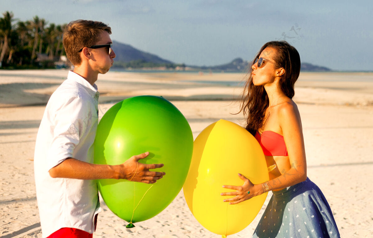 情侣两个快乐的年轻人在沙滩上约会和玩耍的可爱肖像搞笑外遇热带
