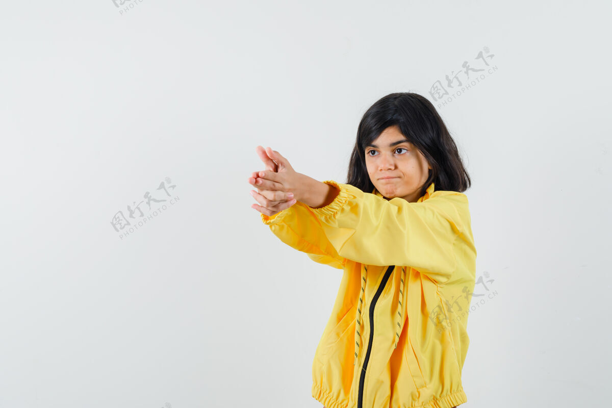 女性穿着黄色连帽衫的小女孩展示了持枪姿势 看起来很自信 正面视图动物脸欢呼