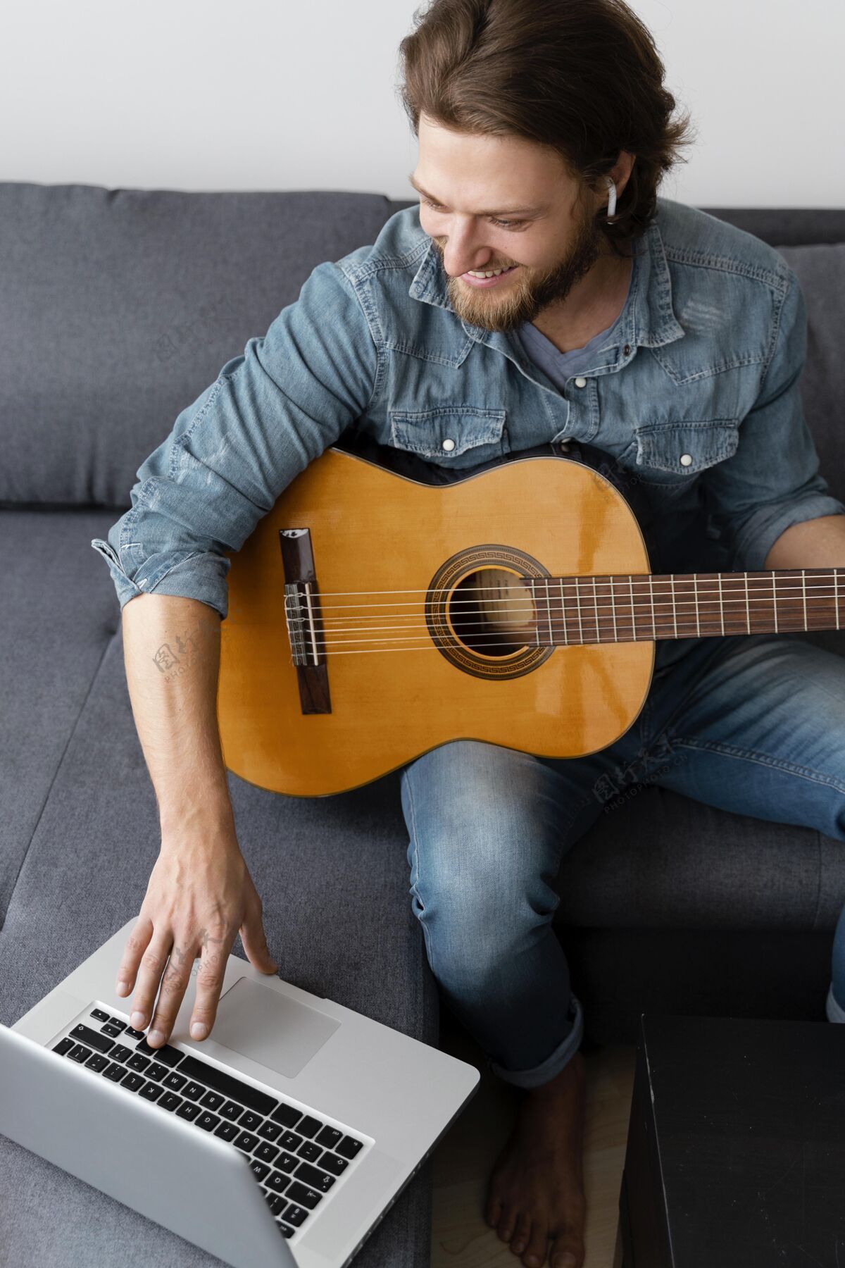 在家里中枪笑脸人吉他和笔记本电脑生活方式放松乐器