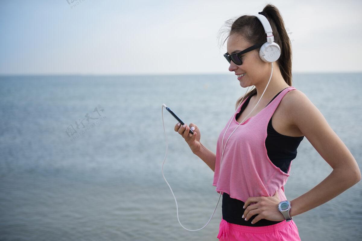 海洋特写在海边慢跑的健康年轻人手机沙滩运动