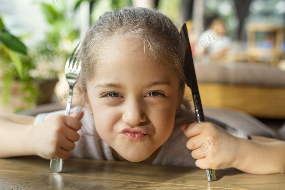 美食特写镜头拿着餐具的心烦意乱的女孩美食食物孩子