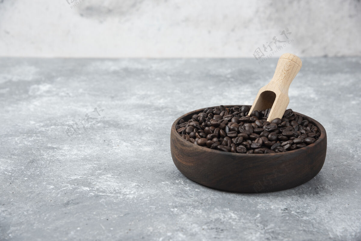 咖啡因木制碗中烤咖啡与勺子大理石表面咖啡粒天然的香气