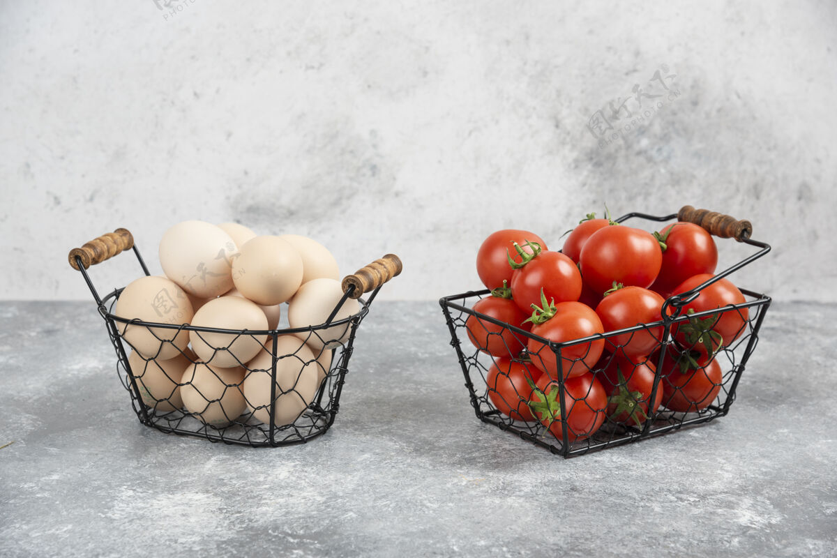 烹饪柳条篮子的生有机鸡蛋和红色西红柿放在大理石上粗麻布食物番茄