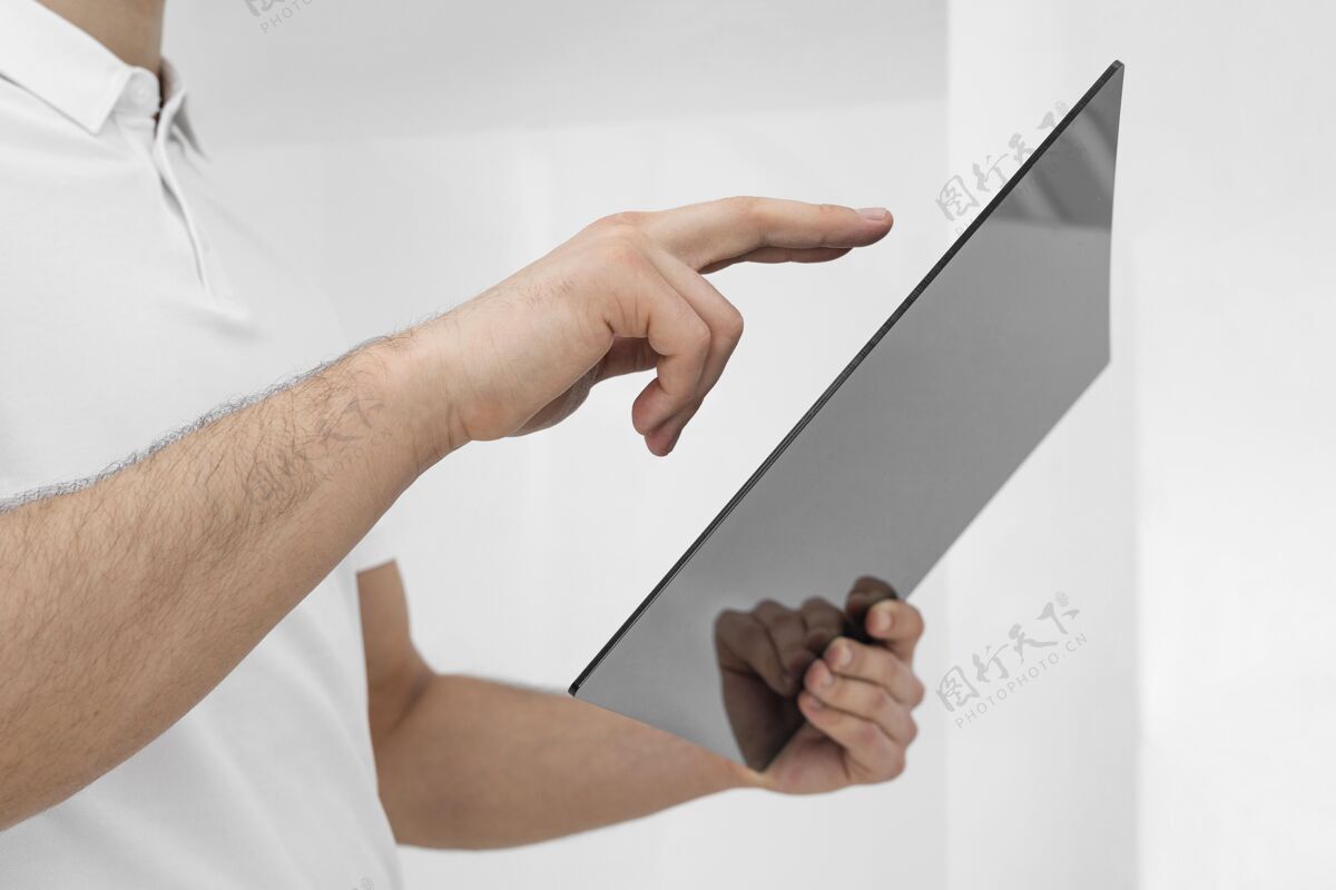 设备穿白色衣服的年轻人用平板特写镜头单色数字平板电脑平板电脑